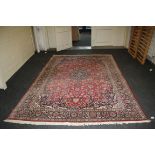 A red ground Kashan carpet with scrolling Islimi decoration, 310 x 210cm