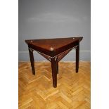 A George III mahogany Chippendale style triangular folding table with shaped pierced detail