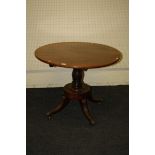 A Regency mahogany centre table, the circular snap top on a baluster column, disc base, four