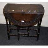 A late Victorian oak gate leg table with carved decoration, 66cm wide