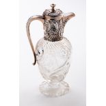 A late Victorian silver mounted claret jug, with embossed fish decoration, the intaglio cut body