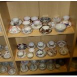 A collection of early 19th century mostly New Hall porcelain, tea bowls and saucers (two shelves)