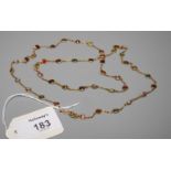A multi-gem-set necklace, the cable link chain set with numerous gem stones within spectacle mounts,