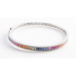 A sapphire and diamond bangle, the central half set with multi-coloured princess cut sapphires in