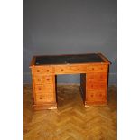 An Edwardian oak kneehole writing desk with inset leather top, 121.5cm