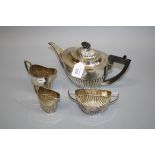 A marked four piece teaset, oval part fluted, the teapot with ebonised finial and angled handle,