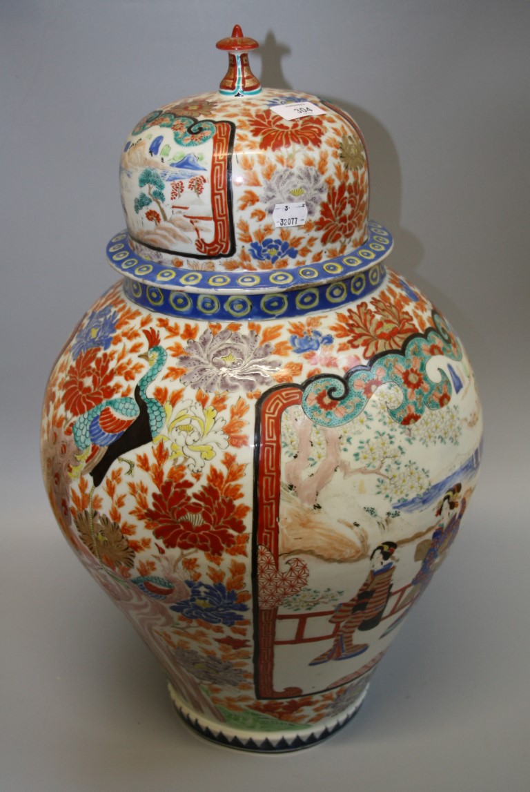 A late 19th century Japanese porcelain jar and cover, painted with panels and figures, 60cm high