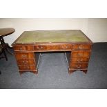 A large reproduction mahogany desk with leathered top, 153cm wide