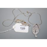 A diamond set pendant and earrings en suite, the figure of eight scroll shaped pendant set with