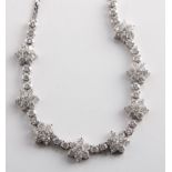 A diamond necklace, mounted with eight seven stone brilliant cut diamond clusters, each cluster