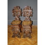 A pair of Victorian Tyrollian style oak hall chairs with deep carved decoration