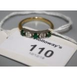 An emerald and diamond rive stone half hoop ring, the alternating circular cut emeralds and