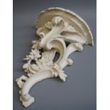 A white painted florally carved Rococco form wall bracket, 46cm