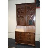 A George III mahogany bureau bookcase, the moulded and arcaded cornice over a pair of boxwood strung