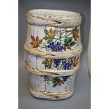 A French faience 'harvest barrel' garden seat painted with fruiting vine decoration, together with a