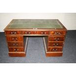A reproduction mahogany pedestal desk with leathered top, 133cm wide