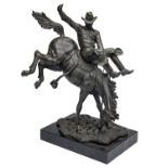 A BRONZE CAST OF A RODEO COWBOY RIDING A BUCKING BRONCO mounted on a marble plinth, measuring