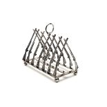 A STERLING SILVER TOAST RACK IN THE FORM OF CROSSED GUNS, formed with triangulated shotguns