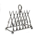 A SILVER-PLATED TOAST RACK WITH CROSSED GUNS, the rack formed with triangulated rifles resting