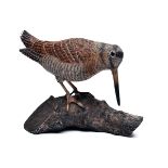MIKE WOOD A FINE HAND-CARVED WOODCOCK, perched on a branch, measuring 8in. in length and standing