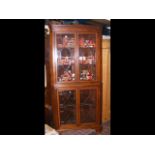An Edwardian corner cabinet with astragal glazed u