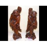 Two Chinese carved hardwood figures, both holding