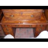 An antique pedestal desk with seven drawers to the