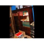 A mahogany bookcase with sliding glazed doors