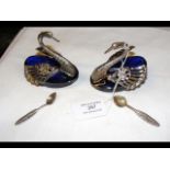 A pair of silver swan table salts with blue glass