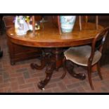 A Victorian oval walnut dining table on shaped sup