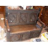 A carved oak antique settle