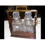 A two bottle tantalus in fitted case