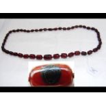 A cherry amber Bakelite necklace with inlaid panel