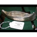 A silver cigar lighter in the form of a canoe by S