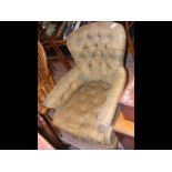 A Victorian button back armchair on turned support