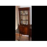 An Edwardian bow fronted display cabinet