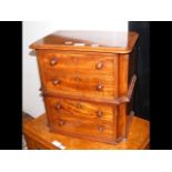 A miniature mahogany chest of four drawers with tu