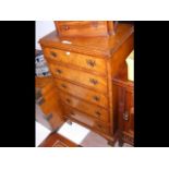 A reproduction walnut chest of five drawers with b