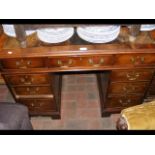A small proportioned pedestal desk with nine drawe
