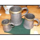 A set of three graduated pewter and brass measurin