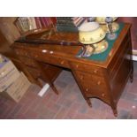 An antique seven drawer desk, with brown leather t