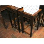 A nest of three oriental hardwood tables with waln