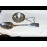 A silver serving spoon, together with silver strai