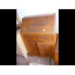 A carved oriental bureau with drawers and cupboard