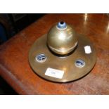 A decorative brass inkwell with cabochon mount