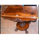 A Victorian rosewood fold-over games table on shap