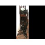 An antique adjustable wrought iron standard lamp