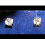 A pair of single stone diamond stud earrings in 18