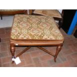 An antique square stool on turned supports