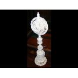 A 38cm high antique carved ivory reticulated ball